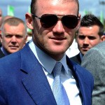 Rooney đeo kính râm, mặc vest xanh thời thượng đi bên cạnh đồng đội Danny Welbeck.